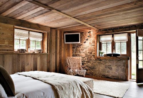 a bedroom with a bed and a stone wall at Chalet Javen - 520m2 avec piscine chauffée et home cinéma in Megève