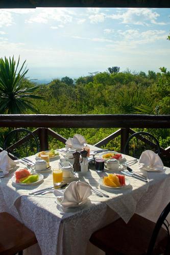 a table with food and fruit on a balcony at The Great Rift Valley Lodge & Golf Resort in Naivasha