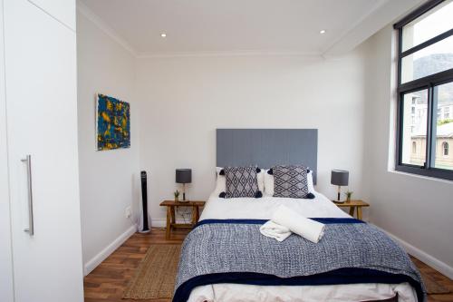 a bedroom with a large bed and a window at Trendy Cape Town CBD Apartment in Cape Town