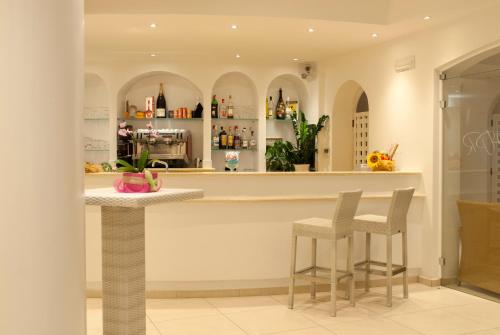 a kitchen with a bar with two stools at Hotel Paradiso in Santa Maria di Castellabate