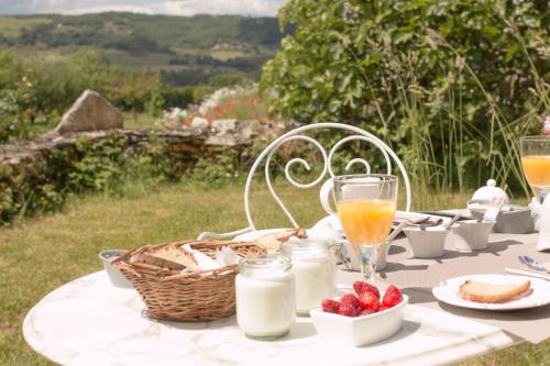 - une table de pique-nique avec un panier de nourriture et de lait dans l'établissement La Bruyle - Chambre d'hôtes de charme, à Saint-Michel-de-Bannières