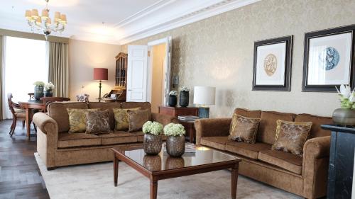 a living room with two brown couches and a table at Althoff Grandhotel Schloss Bensberg in Bergisch Gladbach