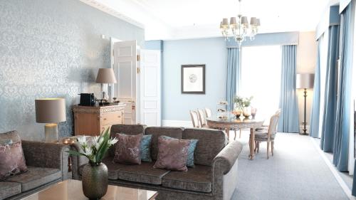a living room with a couch and a table at Althoff Grandhotel Schloss Bensberg in Bergisch Gladbach