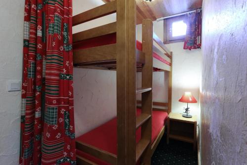 a room with two bunk beds and a table with a lamp at Vacancéole - Résidence Plein Sud in Les Deux Alpes