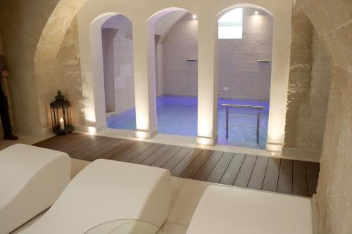 a living room with a white couch and a swimming pool at MONUN Hotel&Spa in Grottaglie