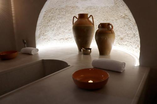 two vases and a candle sitting on a counter at MONUN Hotel&Spa in Grottaglie