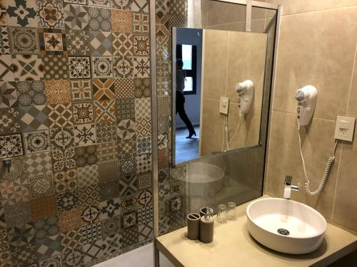y baño con lavabo y espejo. en Cristobal Hotel Boutique en Concordia