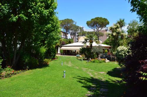 a green lawn with trees and a building in the background at Hotel Villa Ida in Ceprano