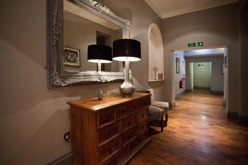 a room with a dresser with two lamps and a mirror at Bannatyne Hotel Darlington in Darlington