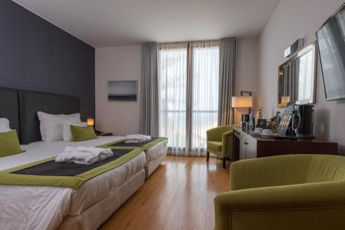 a hotel room with two beds and two chairs at ARTS IN Hotel Conde Carvalhal in Funchal