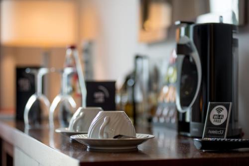 a counter top with two plates and a coffee maker at ARTS IN Hotel Conde Carvalhal in Funchal