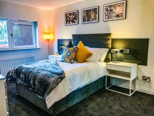 a bedroom with a large bed with pillows and a table at Hydro Apartment with free car park in Glasgow