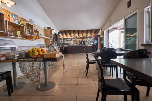 a restaurant with tables and chairs and a bar at Villaggio Turistico Lugana Marina in Sirmione