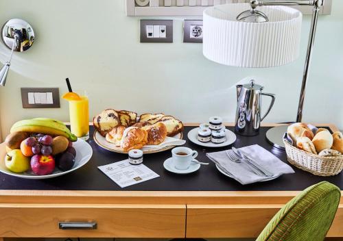 a table topped with plates of bread and fruit at FH55 Grand Hotel Palatino in Rome