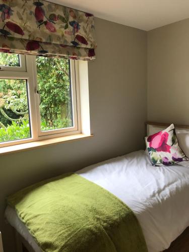 sypialnia z łóżkiem z poduszką i 2 oknami w obiekcie Coastal Retreat w mieście Lowestoft