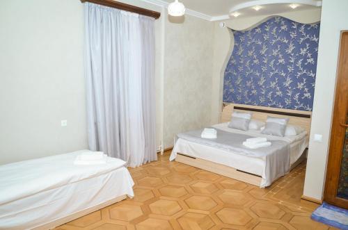 a bedroom with two beds and a blue wall at Rubin Hotel in Goris