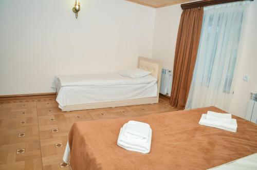 a room with two beds and two white towels at Rubin Hotel in Goris