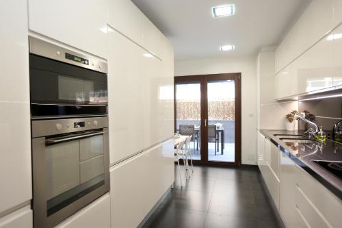 a white kitchen with a stove and a sink at Like-home-T1 Apt-Best Place-Parque das Nações in Lisbon