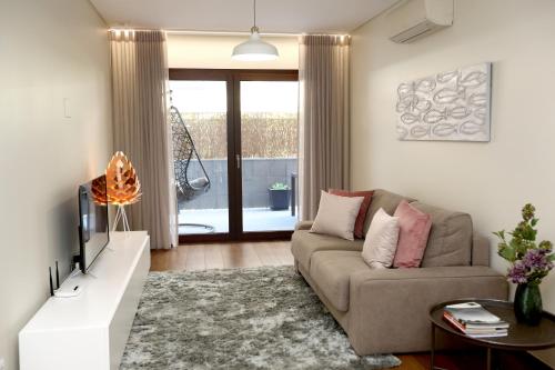 a living room with a couch and a television at Like-home-T1 Apt-Best Place-Parque das Nações in Lisbon