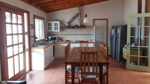 a kitchen with a wooden table and a refrigerator at La Otra Vista in Valparaíso