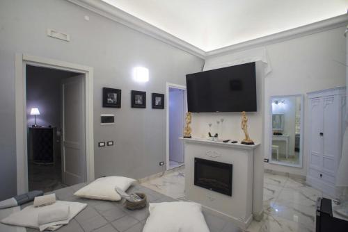 a living room with a fireplace and a flat screen tv at Barberini Dream in Rome