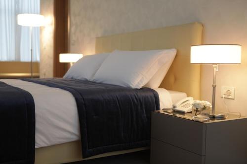 a bedroom with a bed with a phone on a night stand at Best Western Premier Ark Hotel in Tirana