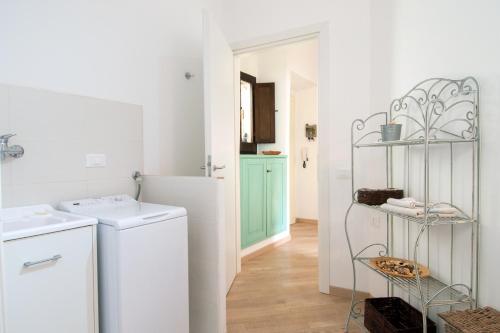 a white laundry room with a washer and dryer at San Domenico 66 in Cagliari
