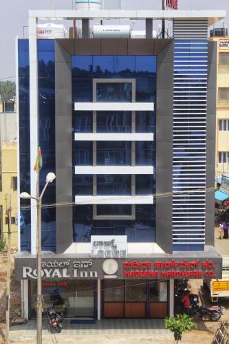 a tall building with a sign in front of it at Hotel Royal Inn in Hiriyūr