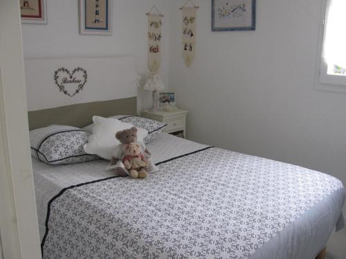 - un ours en peluche assis sur un lit dans une chambre dans l'établissement Résidence le Clos Azur 115, à La Motte