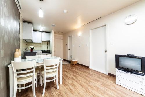 a kitchen and dining room with a table and a tv at HK Resort in Sokcho