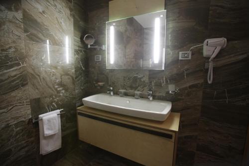 a bathroom with a sink and a mirror at Best Western Premier Ark Hotel in Tirana
