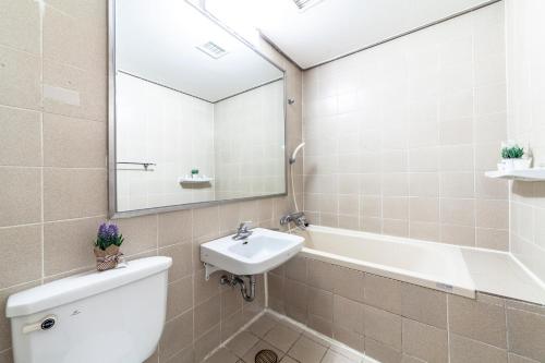 a bathroom with a sink and a toilet and a mirror at HK Resort in Sokcho