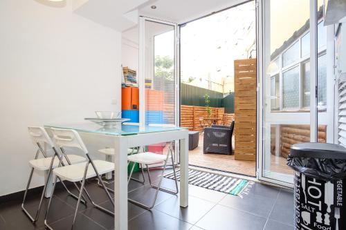 a table and chairs in a room with a window at Tagus 5 Colours Suites in Algés