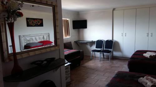a room with a mirror and a bed and a table at Arek's Place in Krugersdorp