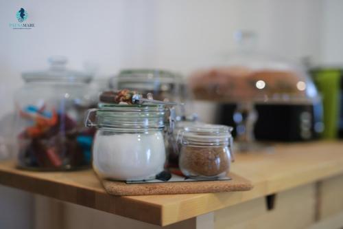 a wooden shelf with jars of food on it at Pausa Mare Apartment in Polignano a Mare