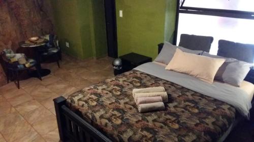 a bedroom with a large bed with towels on it at Arek's Place in Krugersdorp