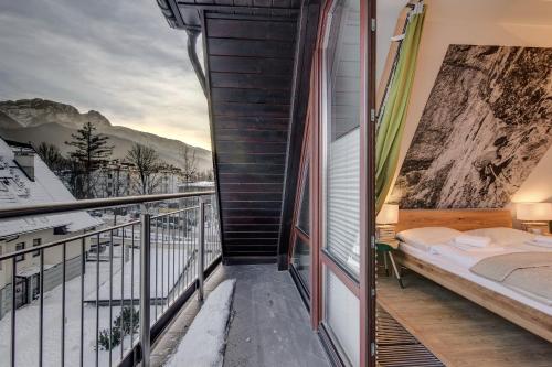 a balcony with a bed and a view of the mountains at Apartamenty Oaza Superior Zakopane in Zakopane