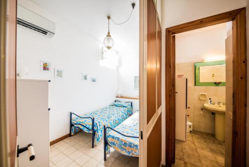 a room with a bed and a bathroom with a sink at Casa MARINELLA in Lipari