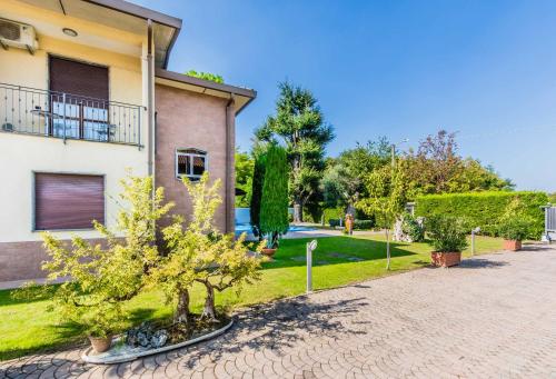 a house with a tree in front of a driveway at B&B SouthItaly in Busto Arsizio