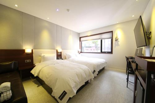 En eller flere senge i et værelse på Brooks Hotel Tongyeong