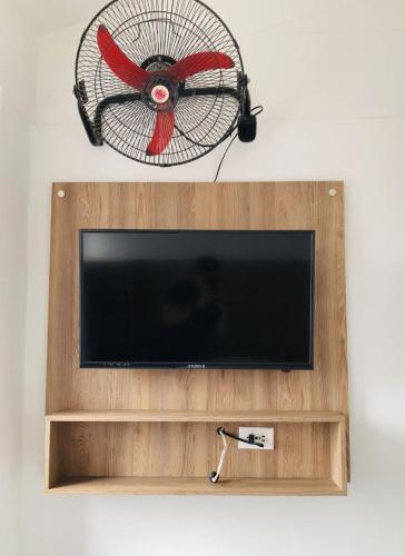a flat screen tv with a fan on a wall at Hotel Center Plaza Plus in Cúcuta