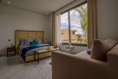 a bedroom with a bed and a couch and a window at Marrakech Holiday in Marrakesh