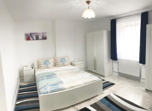 a white bedroom with a bed and a window at Riverside Ski Apartment in Ramingstein