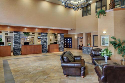 a lobby of a hotel with leather furniture at Pomeroy Inn and Suites Chetwynd in Chetwynd