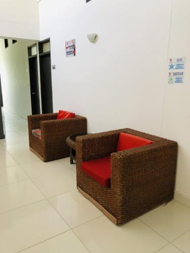 two wicker chairs with a red pillow in a room at Hotel Center Plaza Plus in Cúcuta
