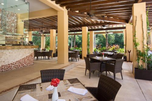 a patio with tables and chairs and a restaurant at Hacienda Tres Rios Resort Spa & Nature Park - All Inclusive in Playa del Carmen