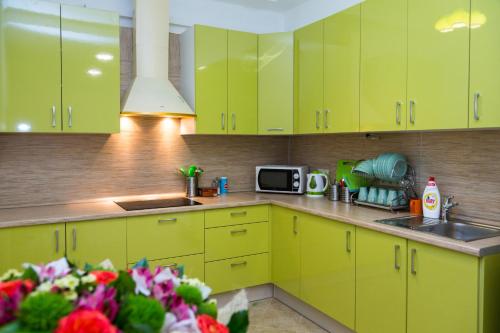 a kitchen with yellow cabinets and a sink and a microwave at Voyage Hotel & Hostel in Moscow