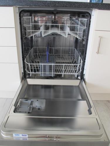 a dishwasher with its door open in a kitchen at Die 5 Ferienwohnungen der Familie Weber in Fehmarn