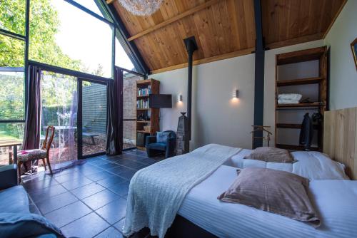 ein Schlafzimmer mit einem Bett und einem großen Fenster in der Unterkunft Het Groene Bed in Oirschot