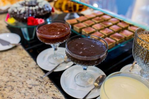 Tres vasos de chocolateinis sobre platos en un mostrador en Beach Hotel Juquehy, en Juquei